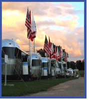 Airstream Region One rally event in Woodstock, CT.  Airstream trailers are lined up with flags proudly displayed at the Woodstock Fairgrounds.